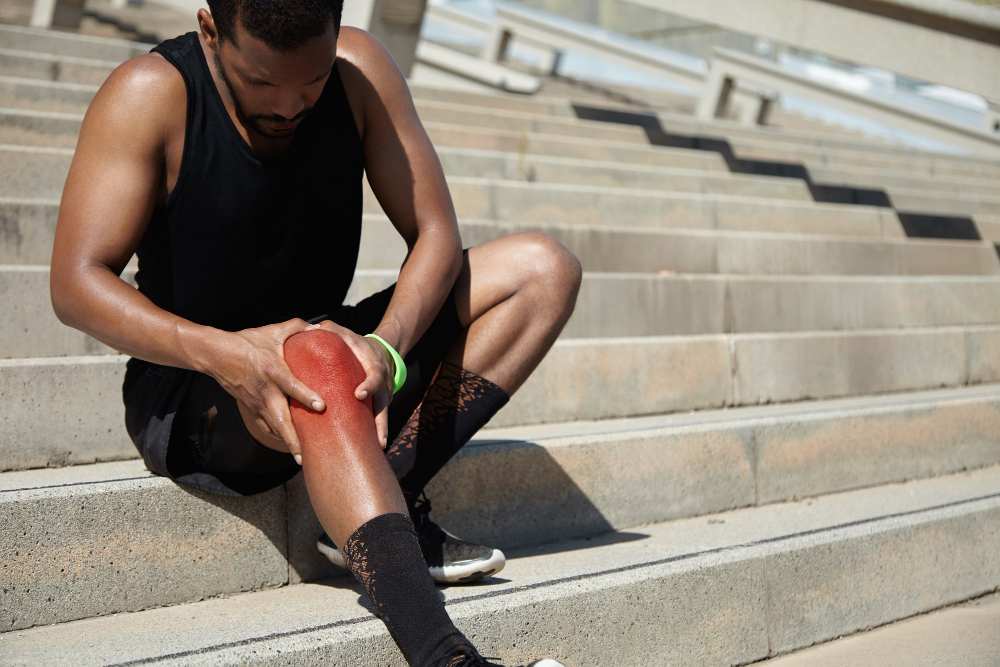 athlete experiencing knee pain during outdoor training in Flint needing sports rehab