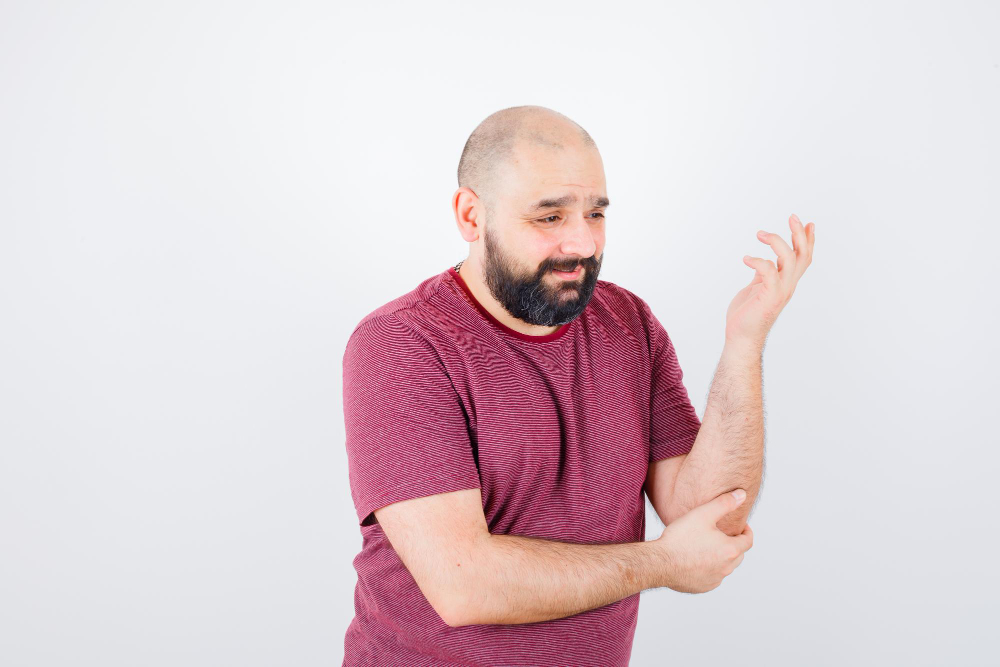 Man experiencing elbow pain in need of physical therapy in Flint, MI