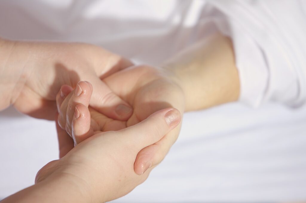 A hand therapist guiding a patient through rehabilitation exercises