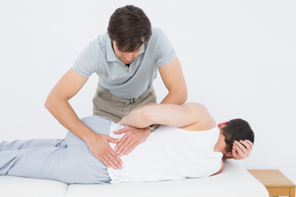 Male physiotherapist examining mans back in the medical office