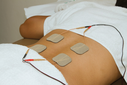 Patient applying electrical stimulation therapy ( TENS ) on his back