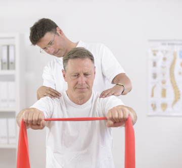Physiotherapy: Senior man doing exercise under supervision of physiotherapist
