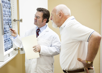 Doctor explains a CT scan of the spine to his senior patient.