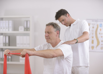 Physiotherapy: Senior man doing exercise under supervision of physiotherapist