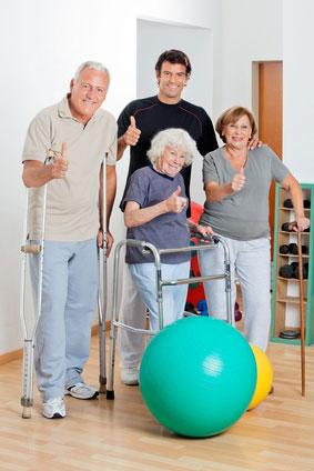 Group of happy senior patients with mobility aids giving thumbs up after a successful fall prevention therapy session in Flint, MI