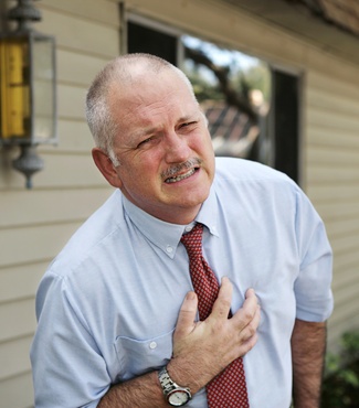 A person clutching their chest in pain, symbolizing a heart attack