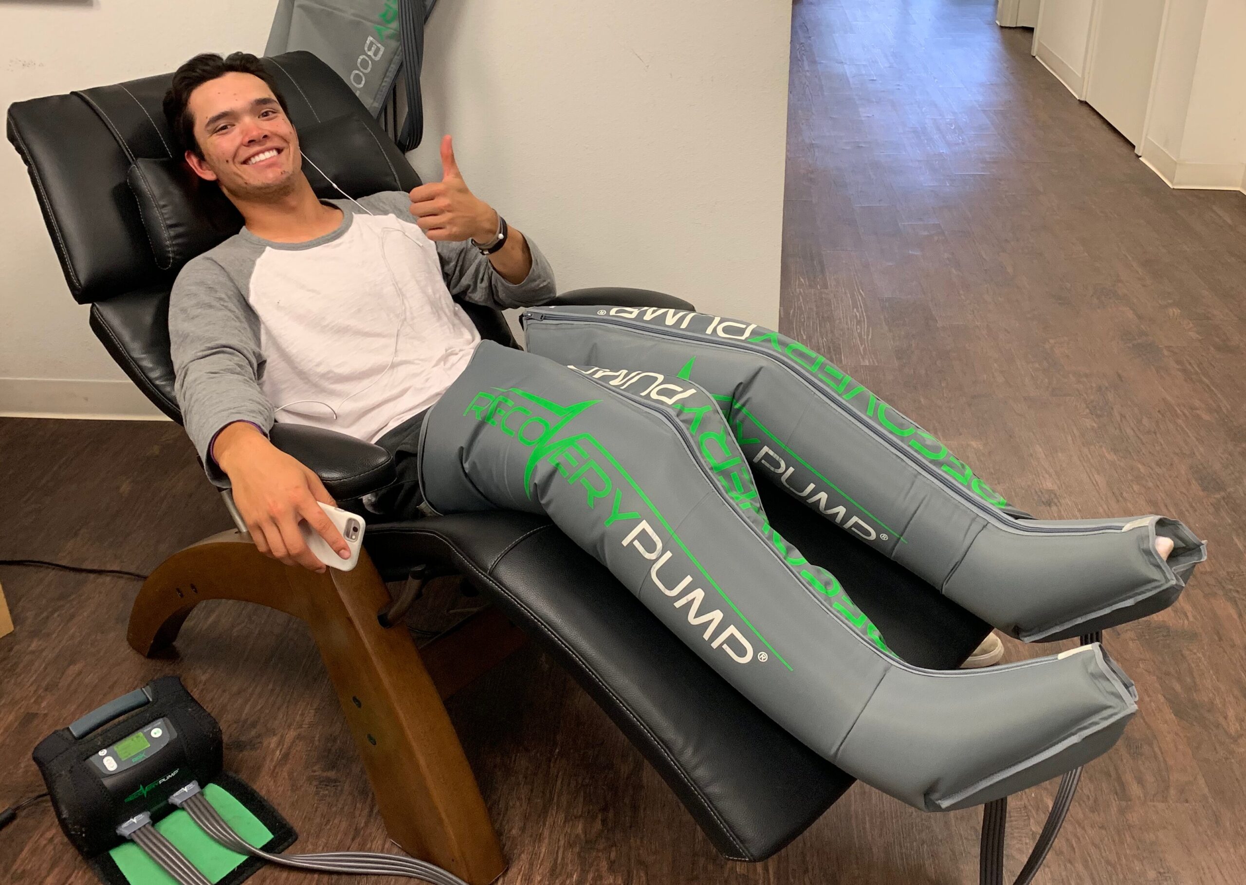 Smiling individual receiving lymphedema treatment with RecoveryPump compression therapy system in a Flint, Michigan physical therapy clinic