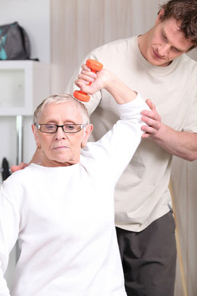 Physical therapist providing specialized elbow treatment to an elderly woman, part of our tennis elbow rehabilitation services in Flint, MI
